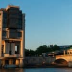 a bridge over a body of water next to a tall building